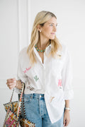 Madison in a white All The Things shirt embroidered with yee haw, a cactus and a cowboy hat, carrying a cowboy boot print tote