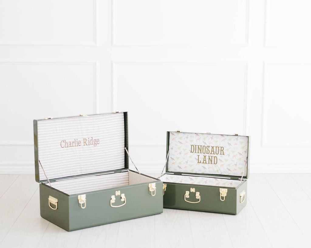 Two open green keepsake trunks personalized Charlie Ridge and Dinosaur Land