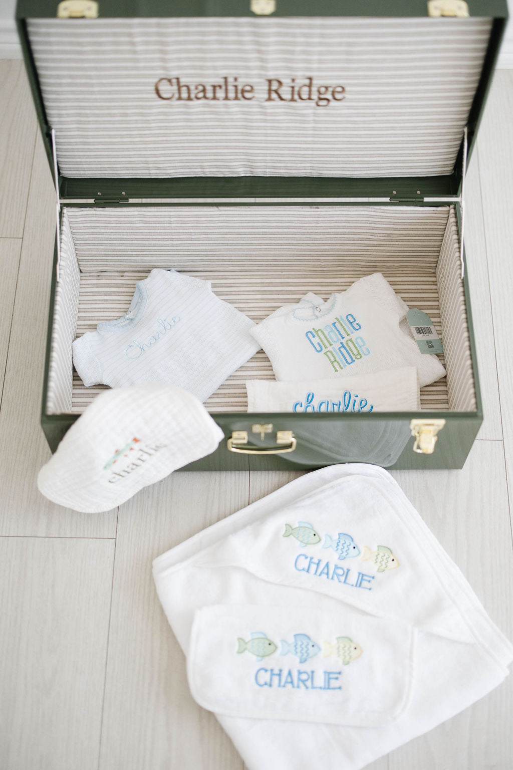 Baby Bundle X-Large: green keepsake trunk stitched Charlie Ridge, filled with outfits, burp cloths, a hooded towel and washcloth