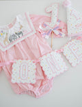 First birthday bundle: polka dot ONE banner, number one cake topper and party hat with a pink romper