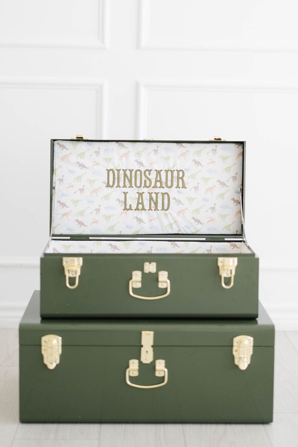 Keepsake Trunk Set in green: a Large and a Small trunk stacked, Dinosaur Land stitched inside the lid