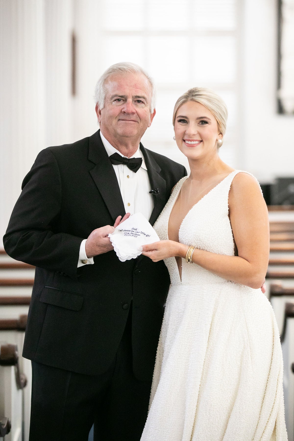 Madison and her dad holding the custom embroidered handkerchief on her wedding day